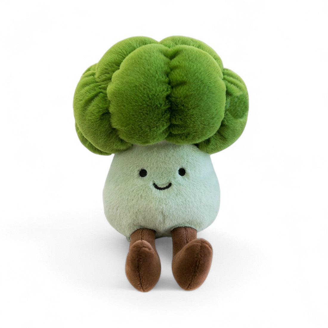 Peluche légume kawaii brocoli souriant verte et blanche de 20 cm assise avec de longues pattes marron vue de face, sur fond blanc.