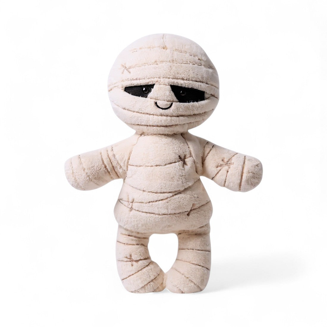 Peluche momie crème aux larges bandes et sourire brodé, sur fond blanc.