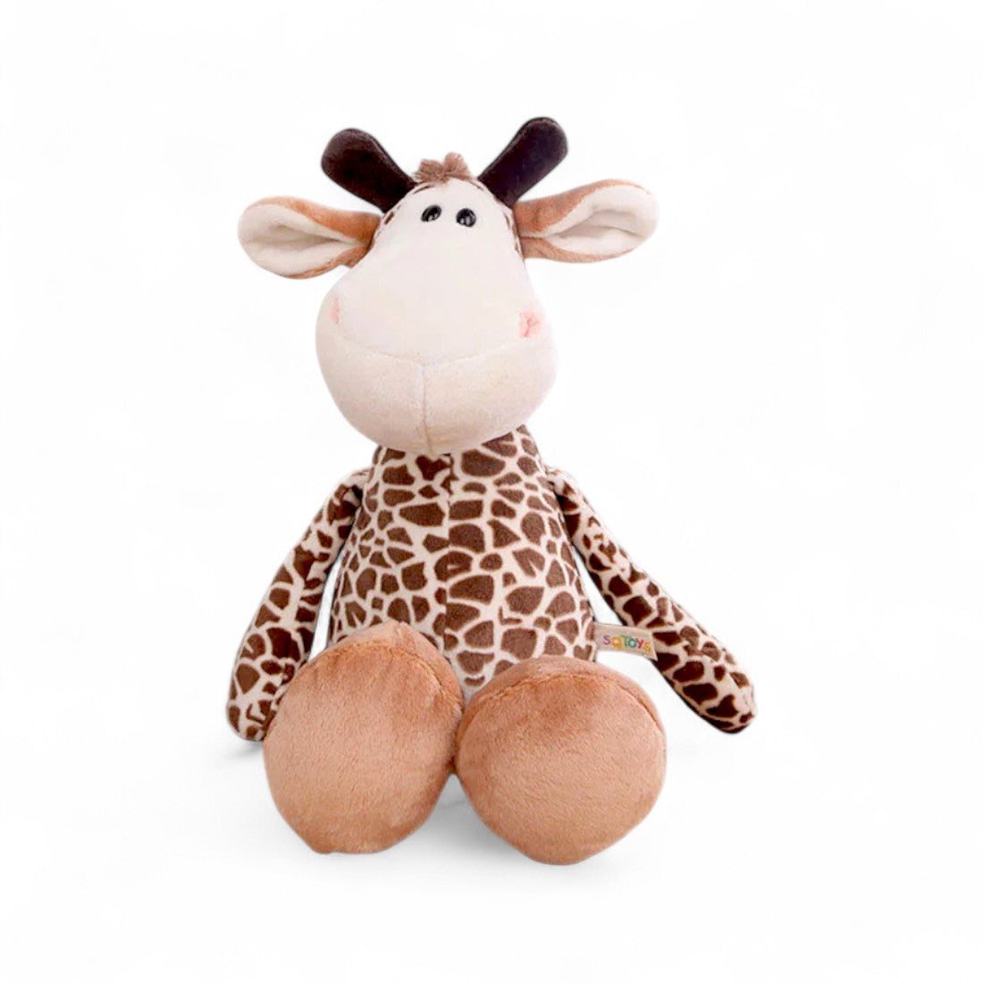 Girafe en peluche marron à tâches, museau rond beige, grandes oreilles et cornes moelleuses, assise et souriante sur fond blanc.