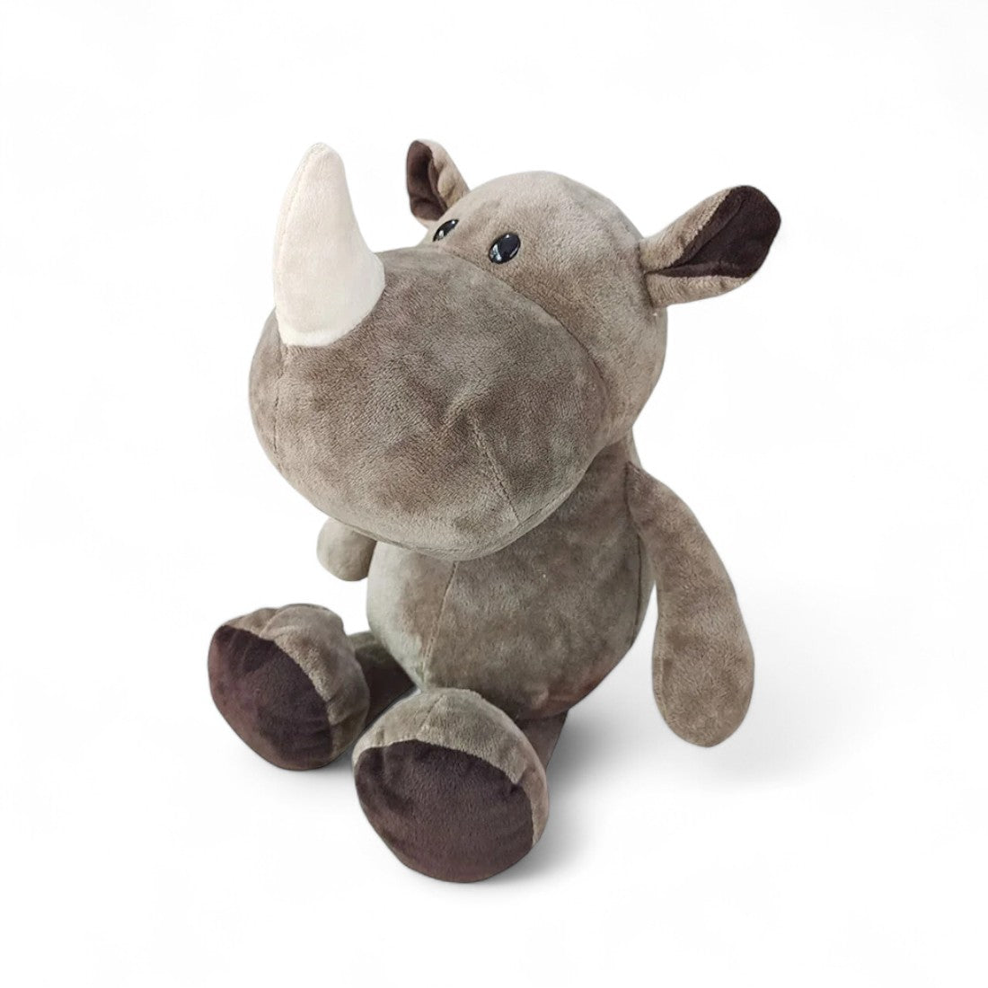 Rhinocéros en peluche gris, museau large, corne blanche moelleuse, assis sur fond blanc.