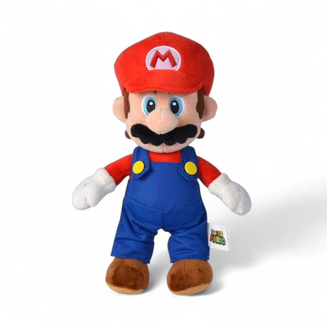 Peluche Mario Super Mario Bros, en salopette bleue, casquette rouge à « M », moustache noire, yeux bleus, moelleuse, sur fond blanc.