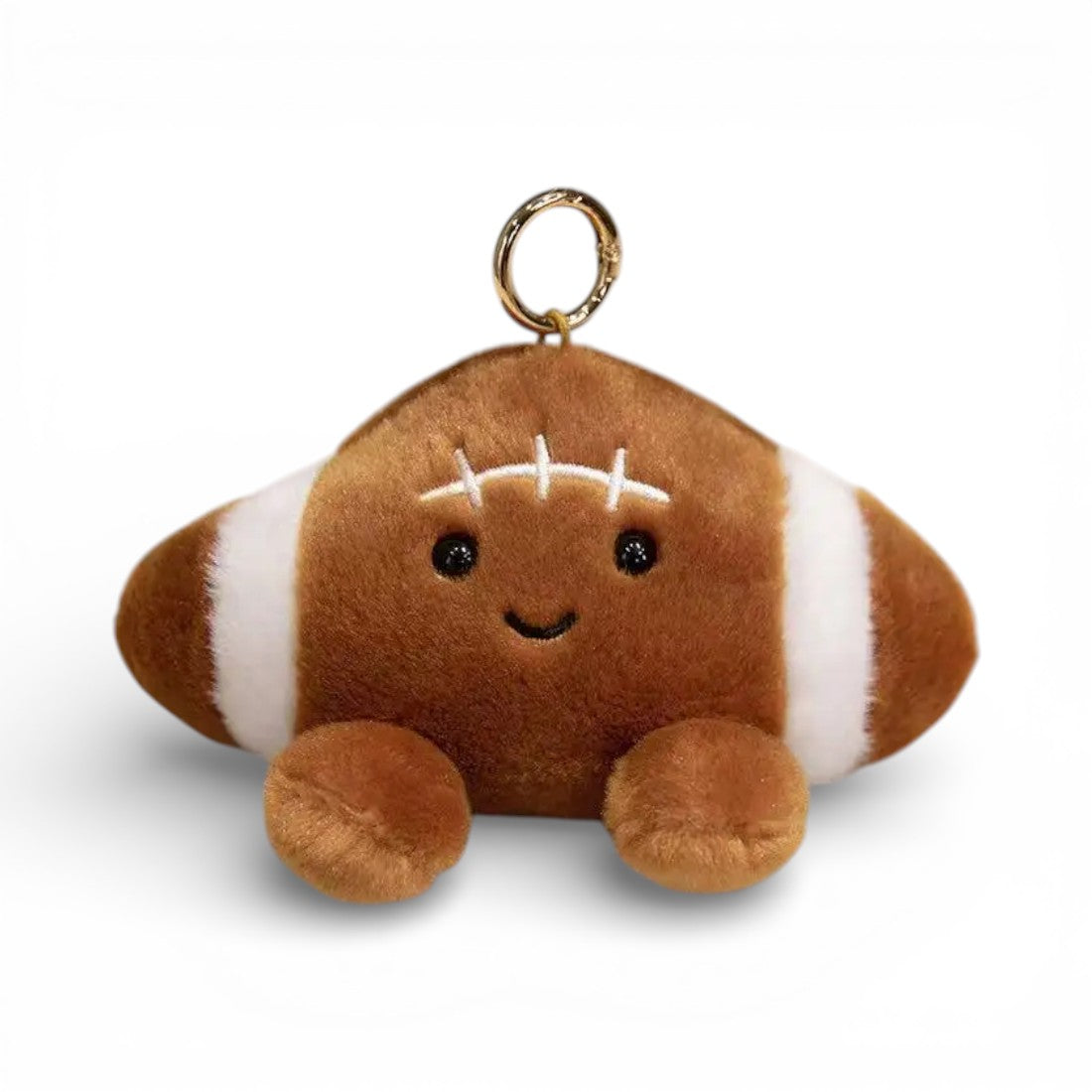 Peluche kawaii en forme de ballon de football américain de 12 cm, cuir marron texturé avec bandes et coutures blanches, grands yeux noirs brillants, sourire joyeux, joues roses, deux pattes marron potelées en bas, anneau doré attaché sur le dessus, sur fond blanc.