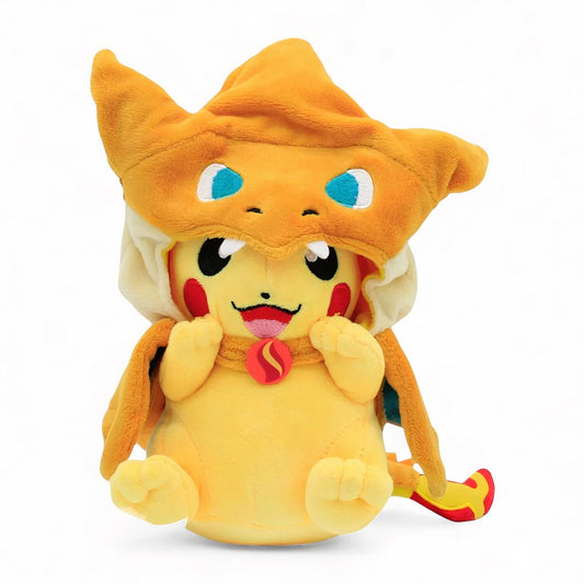 Peluche Pikachu déguisé en Dracaufeu, avec capuche orange et queue de flamme, assis et souriant, sur fond blanc.