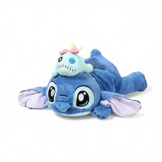 Peluche Stitch allongé avec le doudou de Lilo posé sur sa tête sur fond blanc.