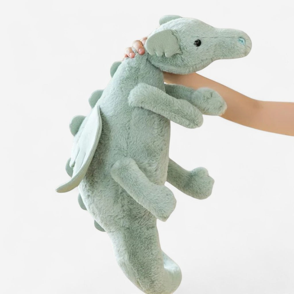 Dragon en peluche aux couleurs pastel - coloris vert tenu à bout de bras