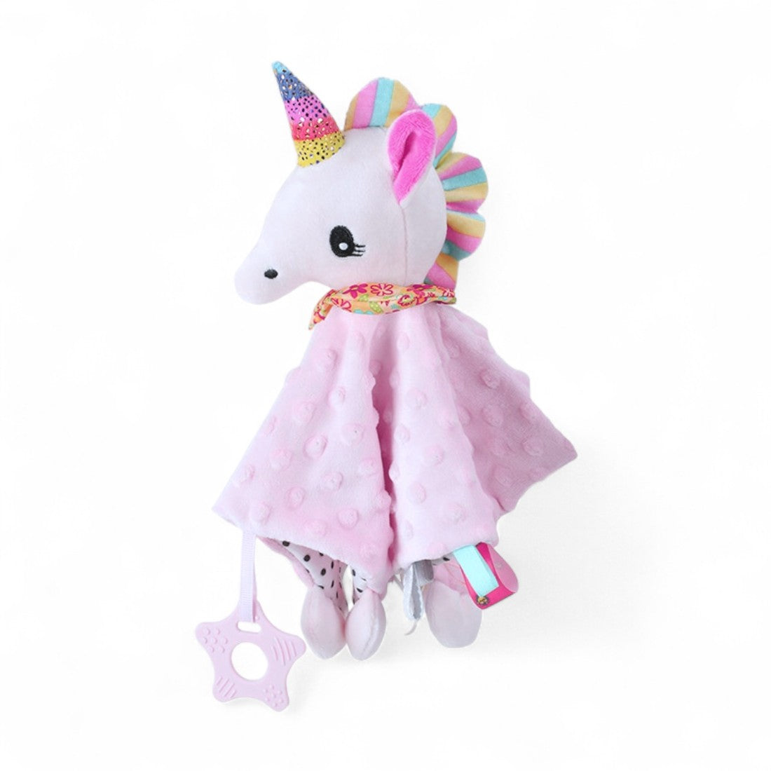 Doudou pour bébé, avec une tête de licorne blanche et corne / crinière au couleur de l'arc-en-ciel, sur un carré doux rose et anneau de dentition accroché ; sur fond blanc.
