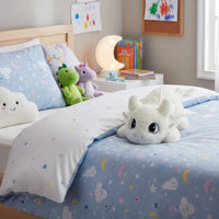 Peluche Dragon blanc Furie éclair moelleuse - posée sur un lit dans une chambre d'enfant