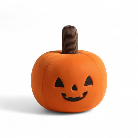 Peluche citrouille orange moelleuse avec sourire noir, sur fond blanc.