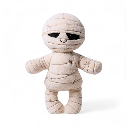 Peluche momie crème aux larges bandes et sourire brodé, sur fond blanc.