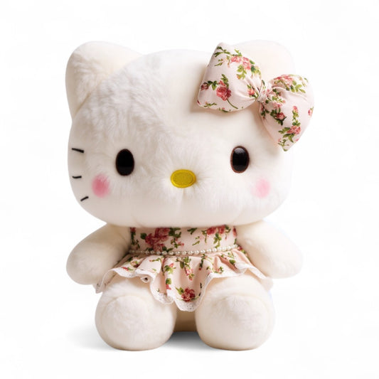 Peluche Hello Kitty blanche avec robe fleurie et nœud assorti, assise sur fond blanc.