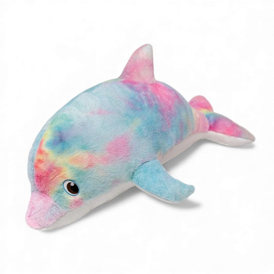 Peluche dauphin très grande, toute douce, avec des couleurs arc-en-ciel pastel sur le dos, le ventre blanc, un œil marron qui brille et posée seule sur un fond blanc.