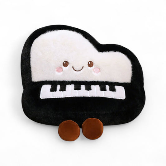 Peluche en forme de piano kawaii noir et blanc avec visage souriant et touches brodées, posée sur fond blanc.