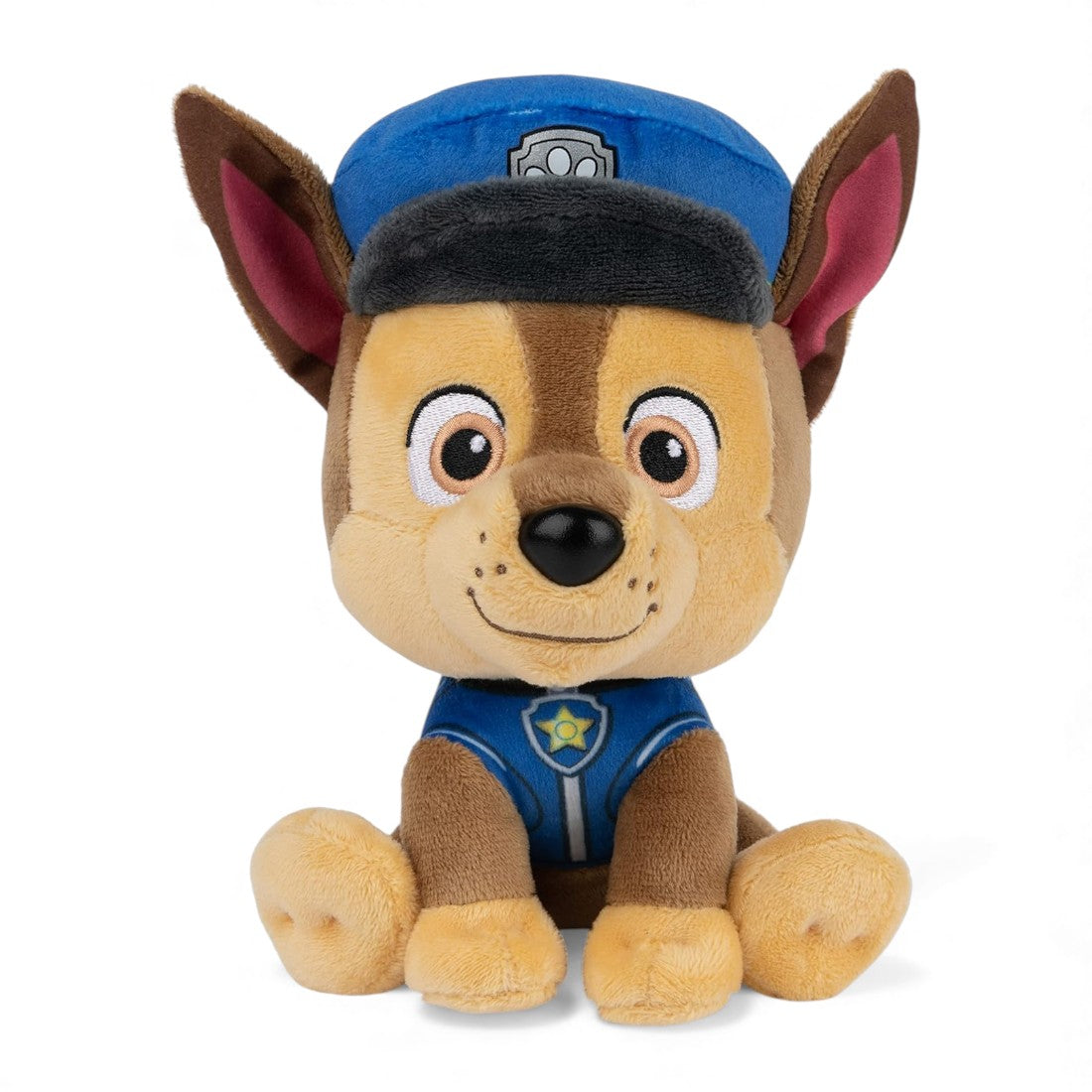 Peluche Chase marron et beige de la Pat’ Patrouille, en uniforme bleu, oreilles dressées, casquette bleue, assise sur fond blanc.