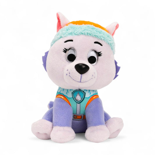 Peluche Everest de la pat' patrouille aux couleurs violette et turquoise, bonnet turquoise bordé d’orange, sourire doux, assise avec grandes oreilles, sur fond blanc.