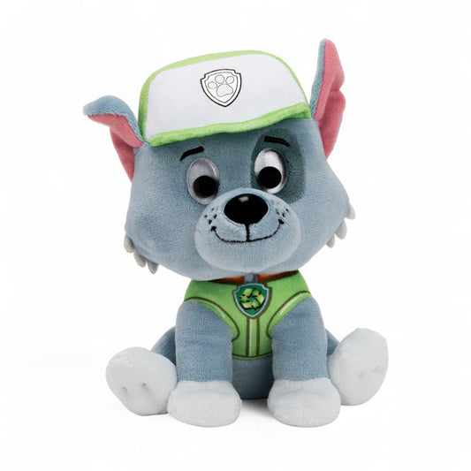 Peluche Rocky en tissu gris et vert, visage souriant, oreilles pointues, casquette blanche et verte, assise sur fond blanc.