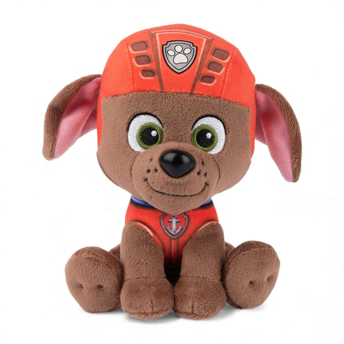 Peluche en forme de chiot Zuma marron de la Pat’ Patrouille, avec casque orange et large sourire, assise sur fond blanc.