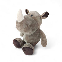 Rhinocéros en peluche gris, museau large, corne blanche moelleuse, assis sur fond blanc.