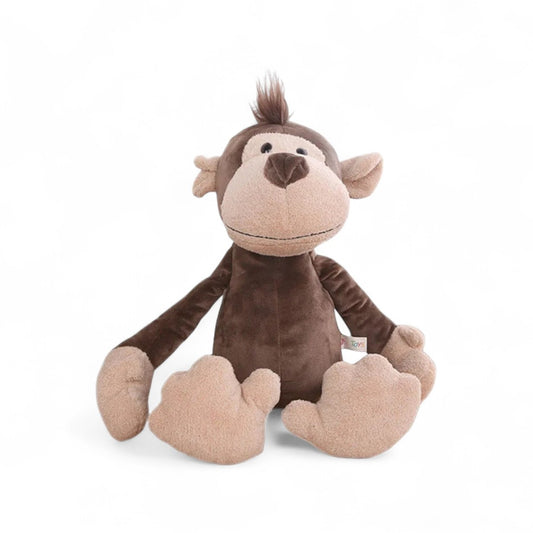 Peluche singe marron, museau beige, touffe sur la tête, grands pieds et mains moelleuses, sourire naïf, assise sur fond blanc.