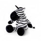 Peluche zèbre rayée noire et blanche, museau noir, grandes pattes et oreilles dressées,  assis sur fond blanc.