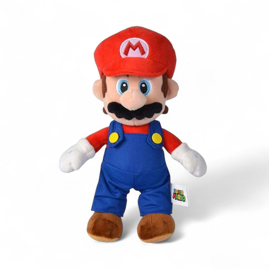 Peluche Mario Super Mario Bros, en salopette bleue, casquette rouge à « M », moustache noire, yeux bleus, moelleuse, sur fond blanc.