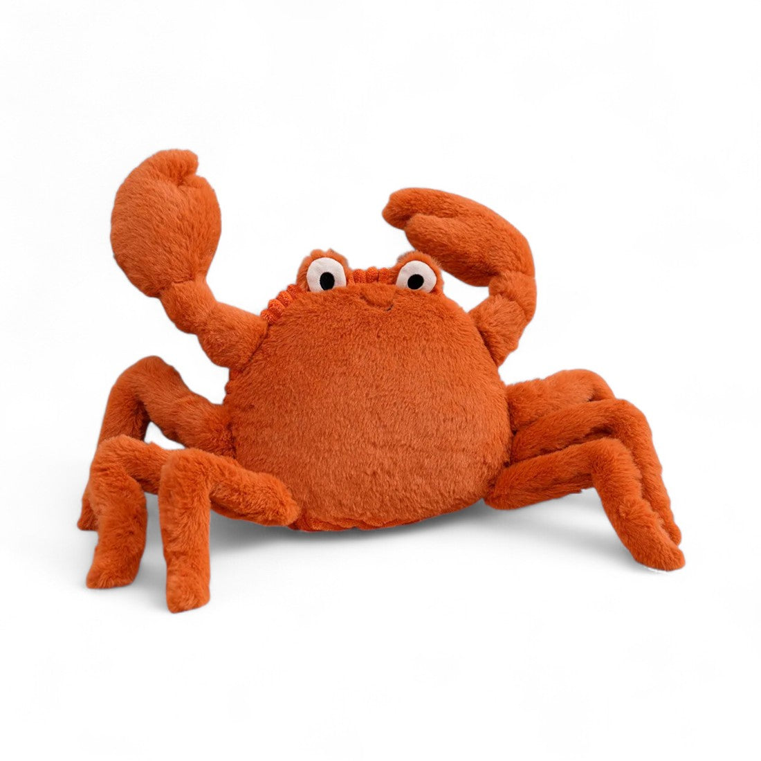 Peluche crabe orange, avec de grandes pinces, des yeux blancs sur le sommet et un sourire brodé ; sur fond blanc