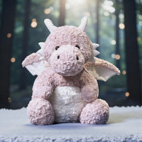 Dragon moelleux en peluche 30 cm - coloris rose, forêt floue en fond
