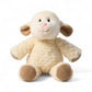 Peluche mouton crème, oreilles et coussinets bruns, sourire brodé, texture laine bouclée, assise moelleuse sur fond blanc
