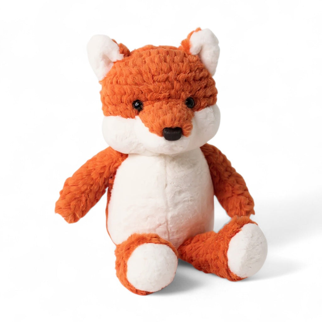 Renard en peluche roux et blanc, museau noir, oreilles dressées, posé assis sur fond blanc.