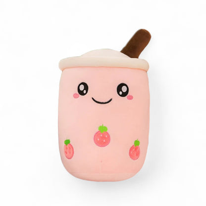 Peluche kawaii en forme de bubble tea à la fraise, rose pastel, visage souriant, paille et motifs fraise, sur fond blanc