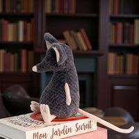 Peluche souris grise exploratrice - de dos, sur une pile de livres