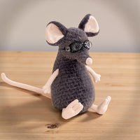 Peluche souris grise exploratrice - avec lunettes sur une table en bois