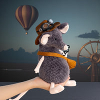Peluche souris grise exploratrice - avec chapeau et sacoche devant une montgolfière