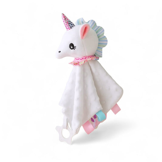 Doudou carré blanc, tête de licorne blanche avec corne brillante et crinière pastel, petites étiquettes colorées sur les côtés, étoile de dentition blanche, sur fond blanc