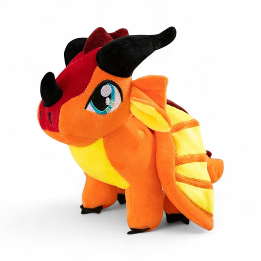 Petit dragon en peluche orange vif, cornes noires, grands yeux turquoise, ailes jaunes à rayures orangées, crête rouge, posture debout, sur fond blanc