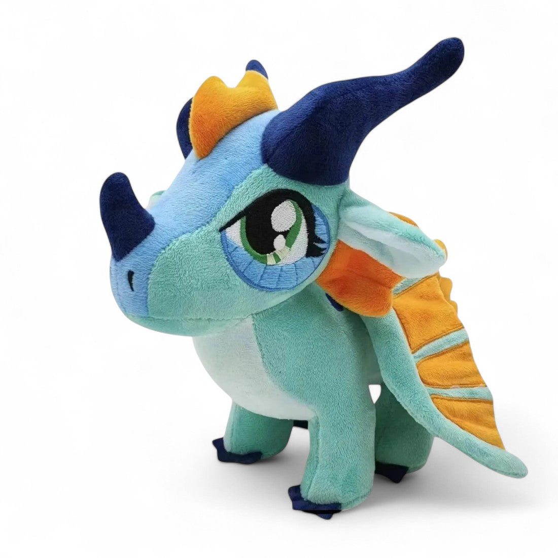 Peluche dragon turquoise avec cornes bleu marine, ailes et crête orange vif, grands yeux verts, sur fond blanc