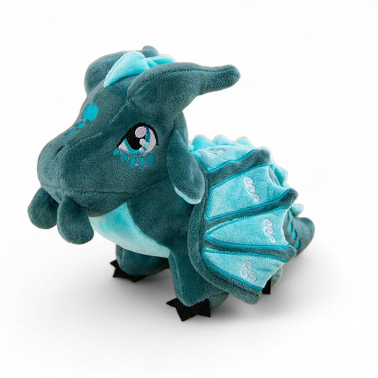 Peluche dragon bleu azur avec ailes brodées, cornes et crête claires, grands yeux brillants, sur fond blanc