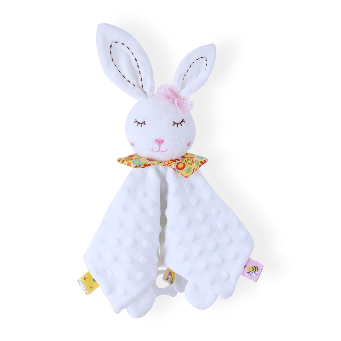 Doudou carré minky blanc à pois en relief, tête de lapin blanche brodée avec yeux fermés, grandes oreilles, fleur en tissu pastel sur la tête, col coloré fleuri, coins en tissu, plusieurs étiquettes colorées, anneau de dentition fixé, posé sur fond blanc