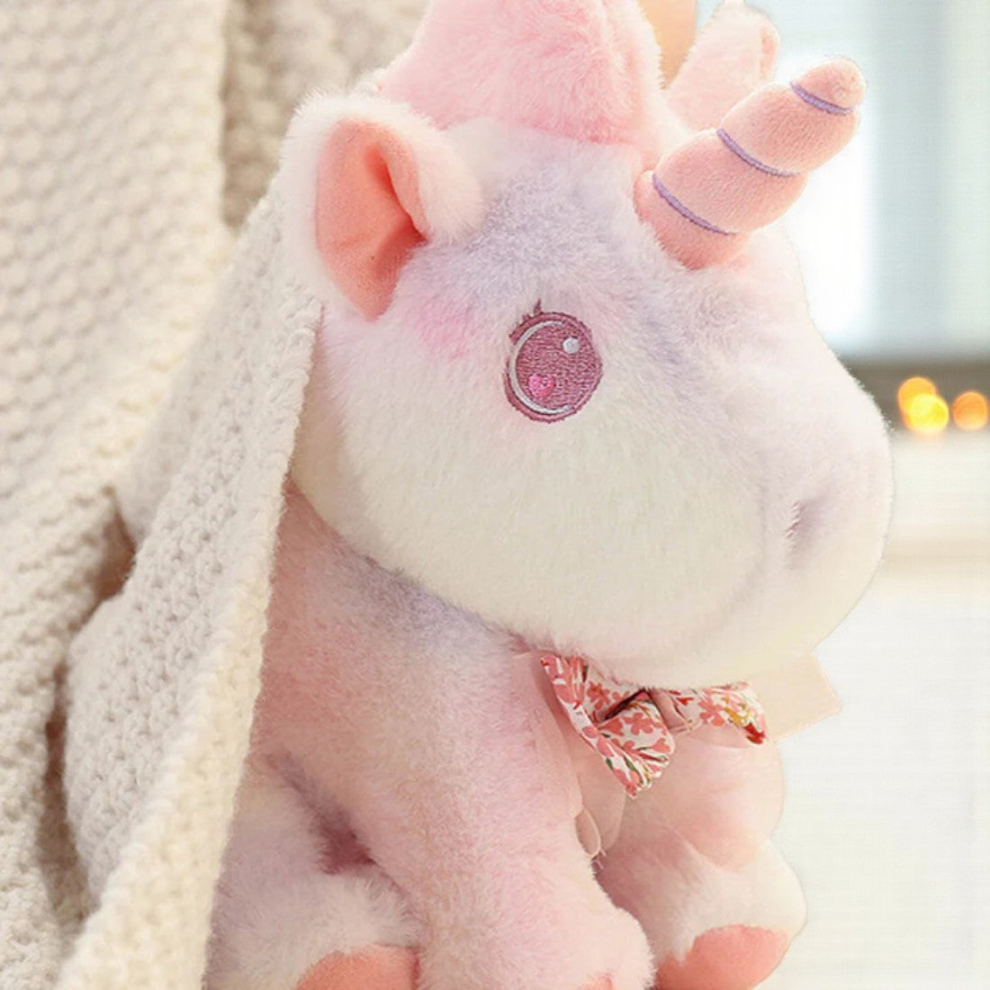 Peluche licorne pastel pour enfant avec nœud fleuri