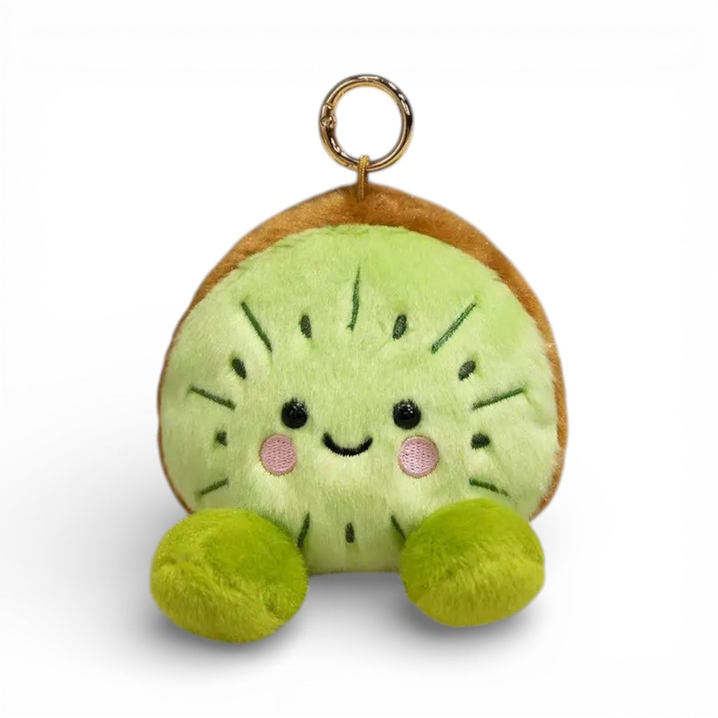 Porte-clé en peluche représentant un kiwi vert texturé avec coque brune veloutée, visage souriant aux grands yeux ronds et joues roses, deux petites pattes vertes en dessous, anneau métallique pour attache, sur fond blanc.