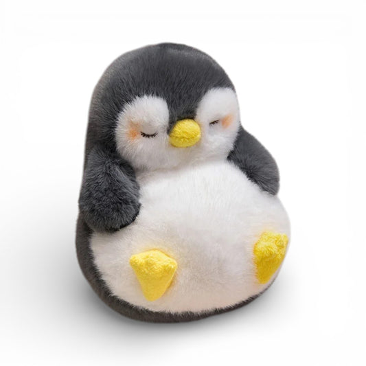 Un gros pingouin noir et blanc aux yeux fermés endormis, bec jaune, ventre blanc rebondi et pattes jaunes, sur fond blanc.