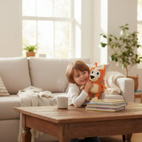 Peluche Bluey – Bingo toute douce - câlinée par un enfant sur un canapé