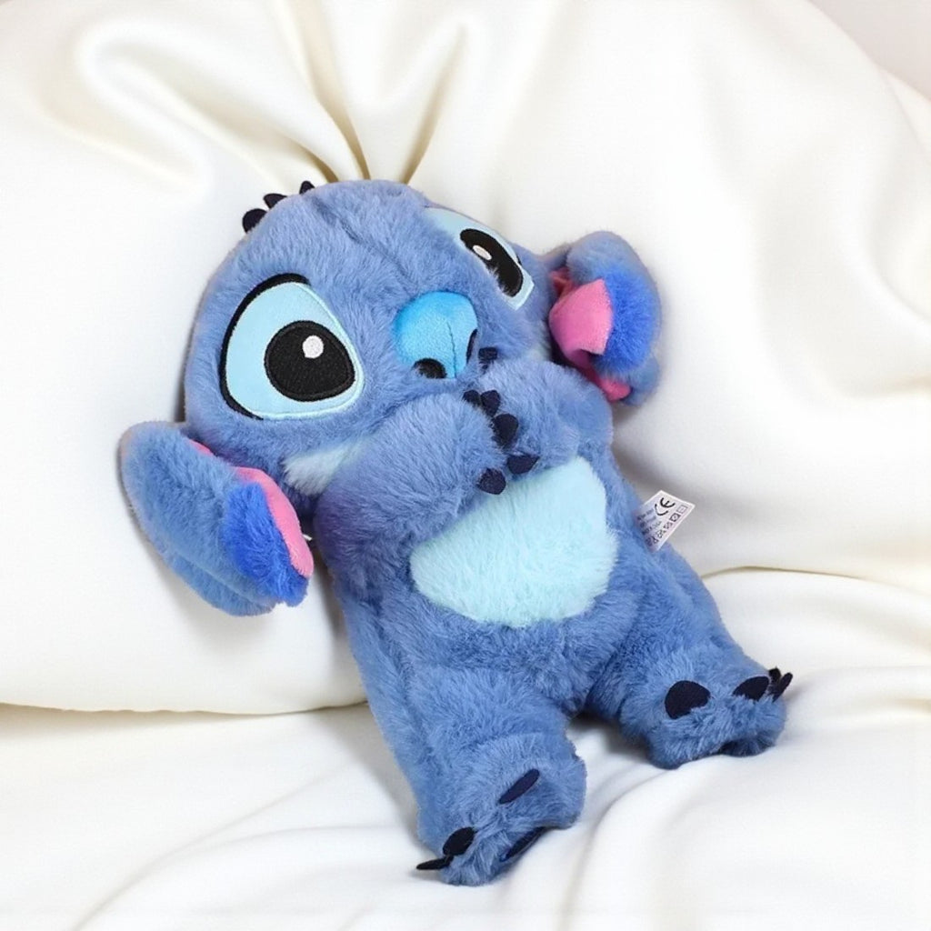 Peluche respirante Stitch veilleuse magique - allongée sur un lit blanc