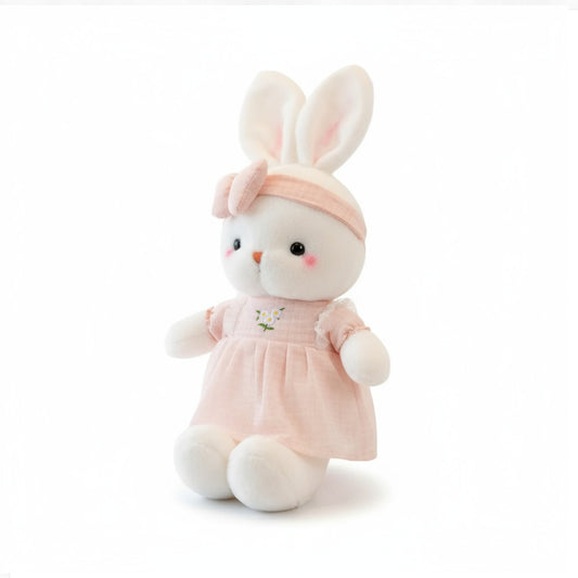 Lapin en peluche blanc avec une robe à fleurs pastel et un nœud assorti sur fond blanc.