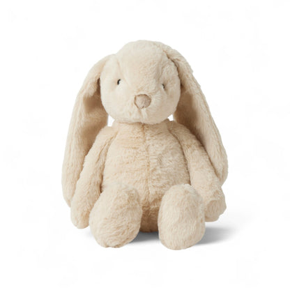 Lapin en peluche moelleux de couleur crème avec de grandes oreilles tombantes, assis droit sur fond blanc.