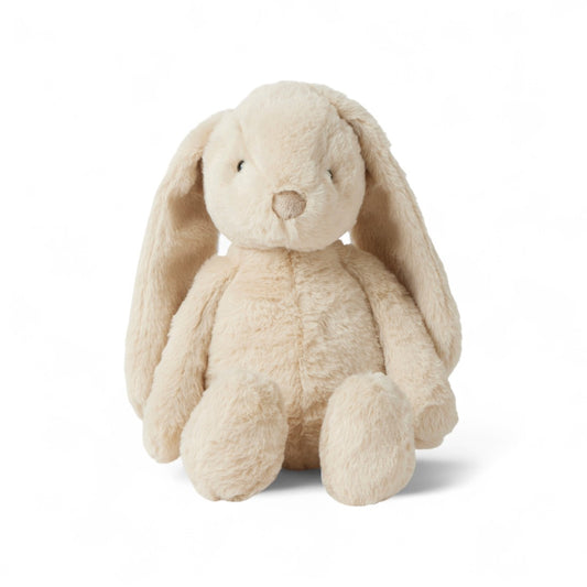 Lapin en peluche moelleux de couleur crème avec de grandes oreilles tombantes, assis droit sur fond blanc.