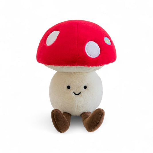 Peluche légume kawaii champignon charmant rouge et blanc de 20 cm assise avec de longues pattes marron vue de face sur fond blanc.
