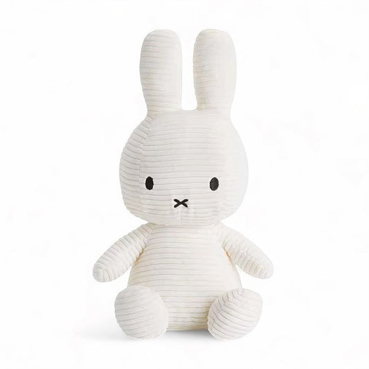 Lapin blanc en peluche côtelé en coton, assis avec ses longues oreilles droites, sur fond blanc.