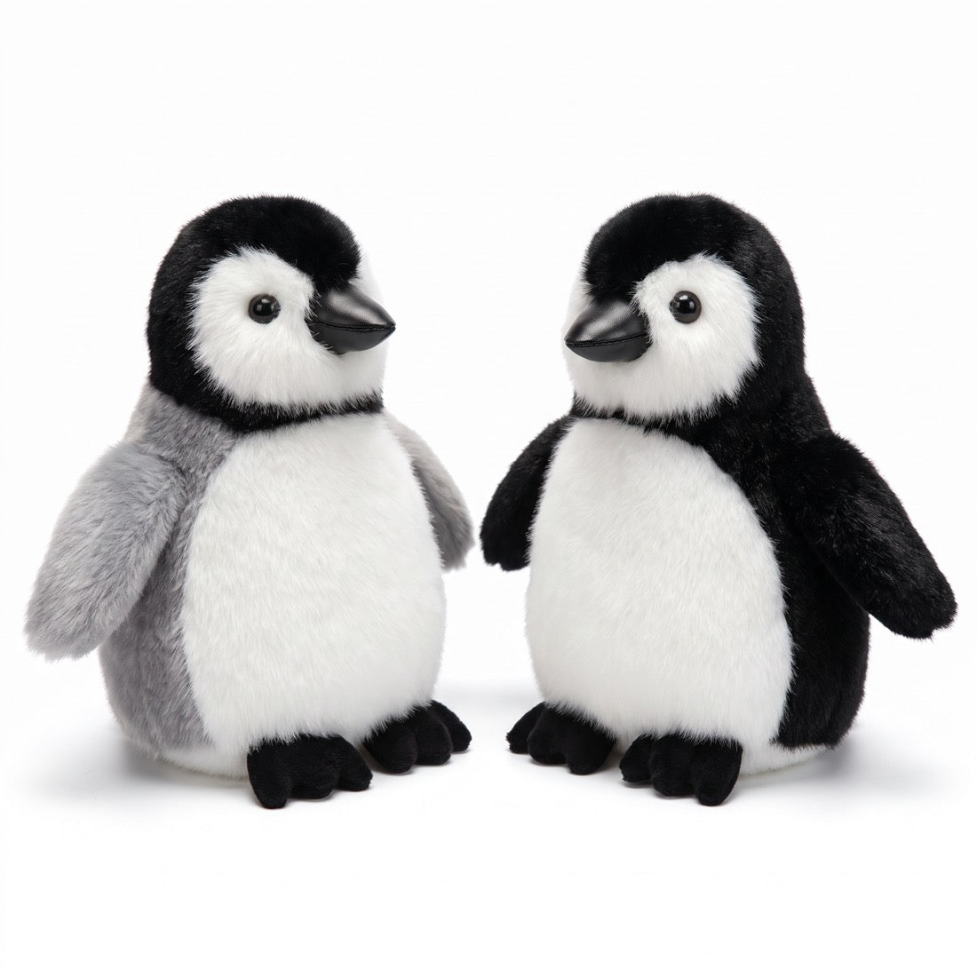 Peluches pingouin grise et noire côte à côte sur fond blanc